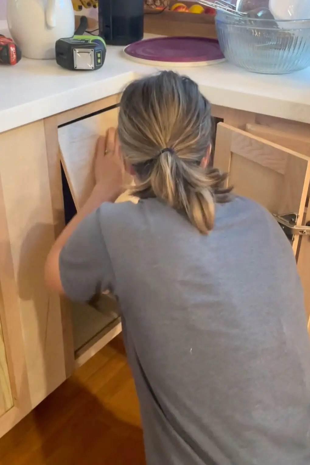 Fitting a shelf into a DIY kitchen cabinet.